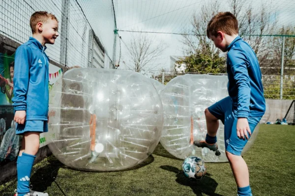 a couple of young men kicking around a soccer ball