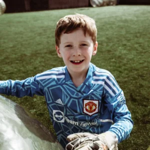 a young boy playing with a bubble ball