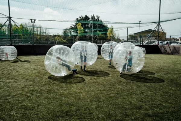 a group of kids in bubble balls on a field