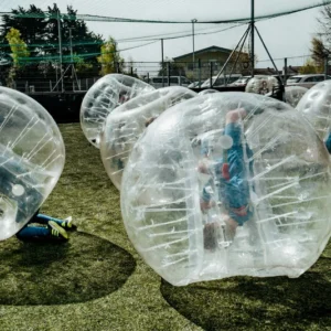 a group of kids playing inside of bubble balls