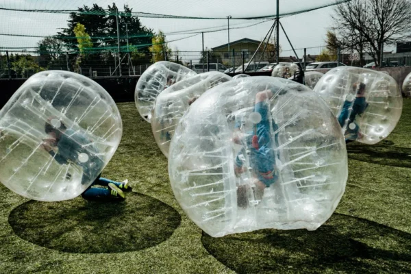 a group of kids playing inside of bubble balls