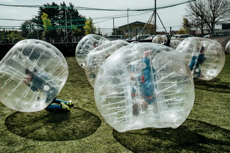 a group of kids playing inside of bubble balls