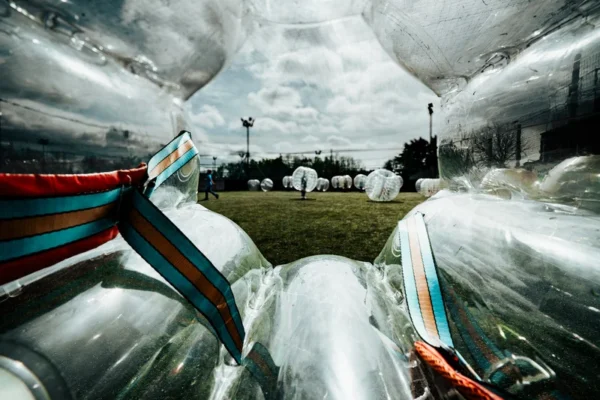 a group of children with Bubble Football on top of a green field
